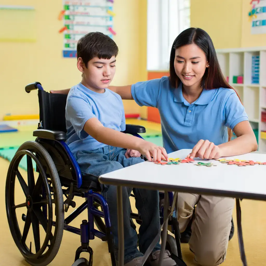 Child in wheelchair engages in activities with support worker, highlighting NDIS disability support services in Perth.